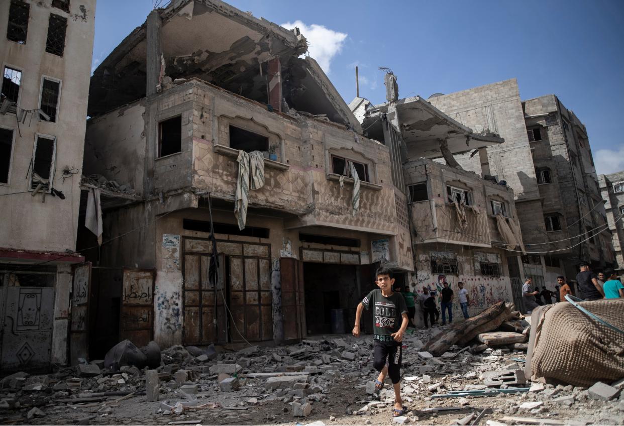 Palestinians inspect damaged houses that were hit in early morning Israeli airstrikes, in Gaza City (AP)