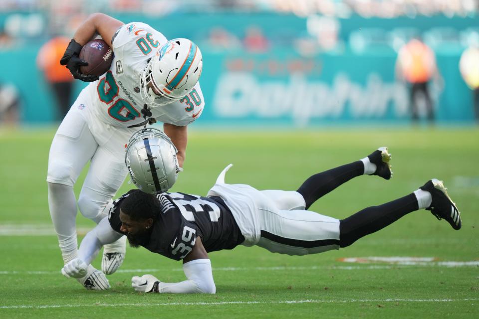 Las Vegas Raiders cornerback Nate Hobbs (39) loses his helmet while trying to make a tackle on Miami Dolphins fullback Alec Ingold (30) during the first half of an NFL game at Hard Rock Stadium in Miami Gardens, Nov. 19, 2023.