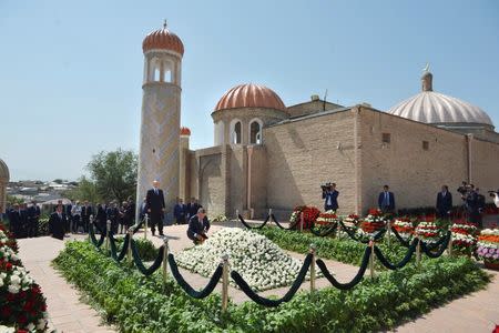 Russian President Vladimir Putin (standing, C) and Uzbek Prime Minister Shavkat Mirziyoyev (below, C) lay flowers at the grave of late Uzbek President Islam Karimov in Samarkand, Uzbekistan, September 6, 2016. Sputnik/Kremlin/Alexei Druzhinin/via REUTERS