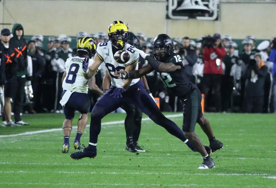 Michigan Wolverines tight end AJ Barner (89) makes a catch against Michigan State Spartans defensive back Chester Kimbrough (12) during second-half action at Spartan Stadium in East Lansing on Saturday, Oct. 21, 2023.