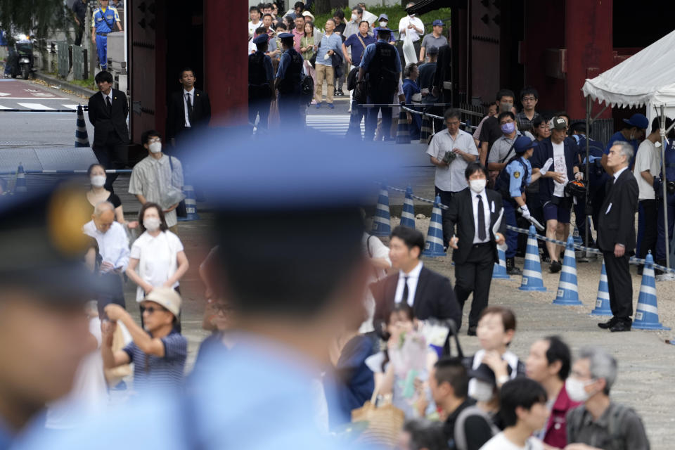 People walk to offer prayer for former Prime Minister Shinzo Abe at Zojoji temple in Tokyo, Japan, Saturday, July 8, 2023. Japan marked first anniversary of the death of Abe who was shot while giving an outdoor campaign speech.(AP Photo/Shuji Kajiyama)