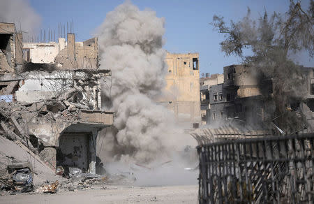 Smoke rises after a landmine exploded as fighters of Syrian Democratic Forces are clearing roads after liberation of Raqqa, Syria October 18, 2017. REUTERS/Rodi Said