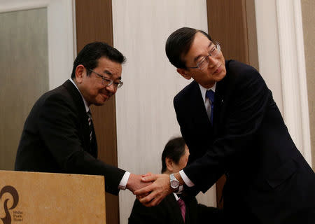 Honda Chief Executive Officer Takahiro Hachigo (L) and Hitachi Automotive counterpart Hideaki Seki shake hands at a news conference in Tokyo, Japan, February 7, 2017. REUTERS/Kim Kyung-Hoon