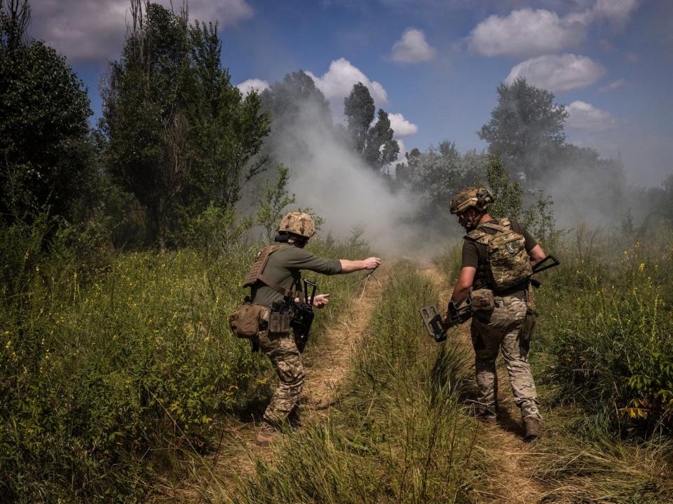 oldiers prepare to clear an anti tank mine by using rope to remove the detonator during a mine clearance training exercise