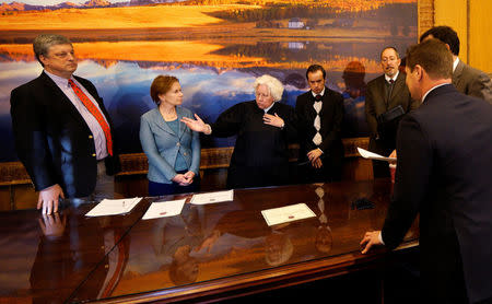 Wayne Williams (L), Colorado Secretary of State, listens with Colorado Lt. Governor Donna Lynne (2nd L) as Hon. Nancy Rice, Chief Justice of the Colorado Supreme Court speaks with attorneys presenting a legal challenge before the Colorado Electoral College electors took the oath of office at the State Capitol in Denver, U.S., December 19, 2016. REUTERS/Rick Wilking