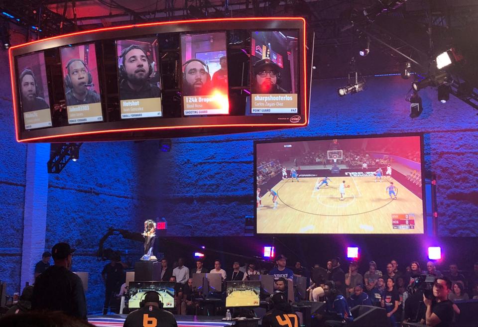 Heat Check Gaming players are seen on the screens above their seats while action from their game against Knicks Gaming is shown on another screen, Saturday, Aug. 25, 2018, in New York.