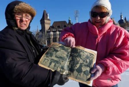 Two elderly women show a 1936 newspaper with a pictures story about the City Park Ice Rink in Budapest, Hungary, January 6, 2017. REUTERS/Laszlo Balogh