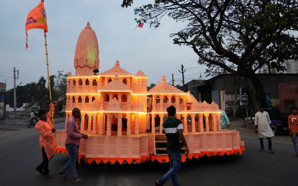 Devotees with a model of the new temple