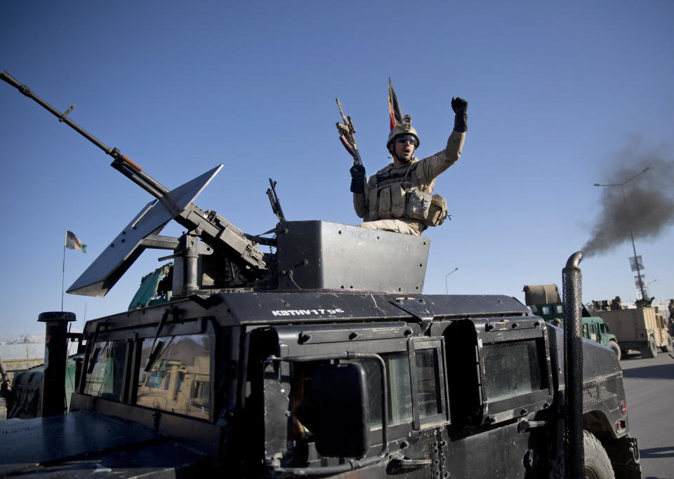 An Afghan special forces soldier gestures from the gun turret of a humvee after his unit took over control of an election office after the Taliban launched an assault with a suicide bomber detonating his vehicle in Kabul, Afghanistan, Tuesday, March 25, 2014. Gunmen stormed into the building, trapping dozens of employees inside and killing many people. A candidate for a seat on a provincial council was among those killed, along with an election worker, a civilian and a policeman. (AP Photo/Anja Niedringhaus)