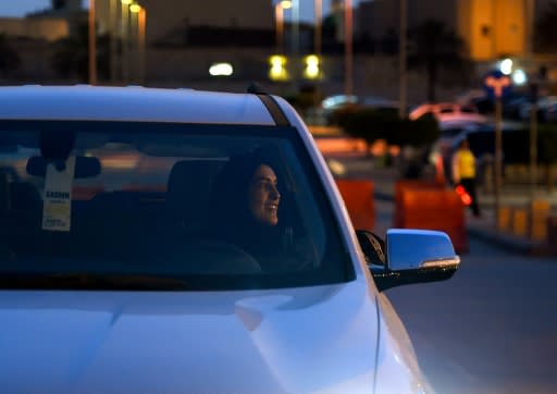 A Saudi woman test-drives a car during an automotive exhibition for women in the capital Riyadh on May 13, 2018