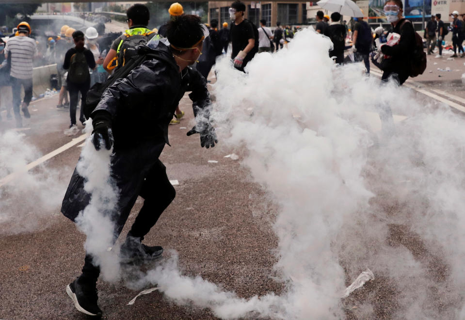 A protester throws a tear gas canister during a demonstration against a proposed extradition bill in Hong Kong, China June 12, 2019. REUTERS/Tyrone Siu