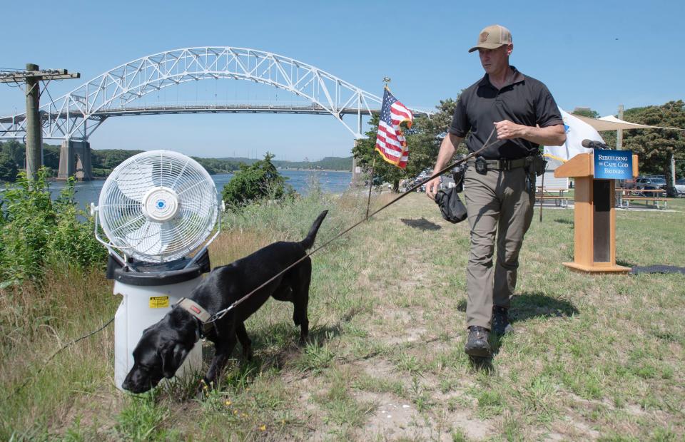 Heavy security was in place along the Cape Cod Canal on Tuesday at Sagamore Beach as a state police explosive sniffing dog goes over the area before officials arrived for a press conference highlighting recent funding that will allow the replacement of the Sagamore Bridge.