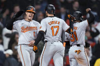 Baltimore Orioles' Colton Cowser, center, is congratulated by Ryan Mountcastle (6) after his three-run home run against the Boston Red Sox during the 10th inning of a baseball game Thursday, April 11, 2024, in Boston. (AP Photo/Charles Krupa)