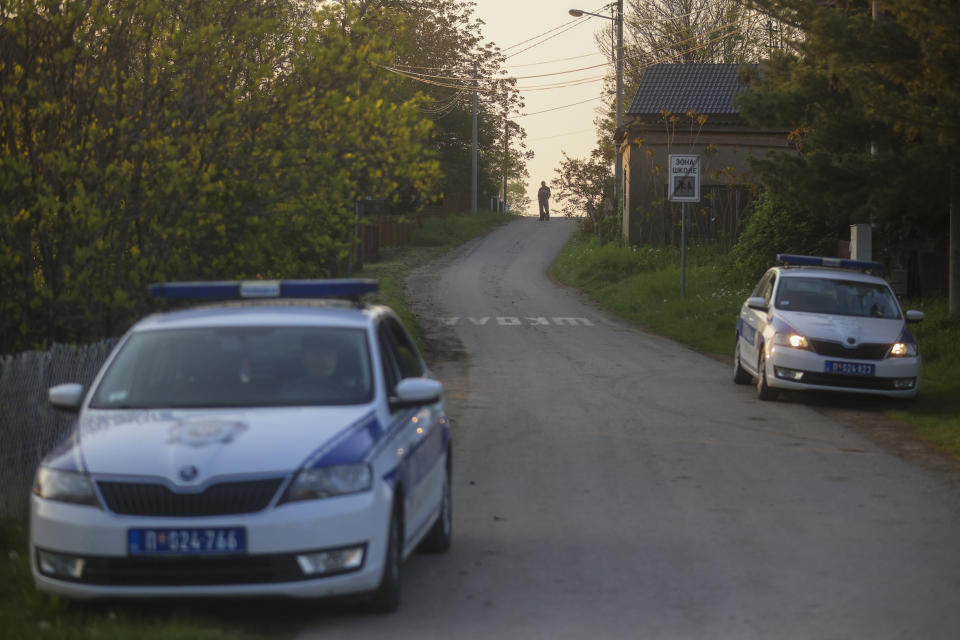 Police officers guard a road in the village of Dubona, some 50 kilometers (30 miles) south of Belgrade, Serbia, Friday, May 5, 2023, as they block the road near the scene of a Thursday night attack. A shooter killed multiple people and wounded more in a drive-by attack late Thursday in Serbia's second such mass killing in two days, state television reported. (AP Photo/Armin Durgut)