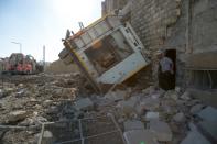 A Syrian rescuer walks amidst destruction following an air strike in the rebel-held Ansari district in the northern Syrian city of Aleppo on September 23, 2016