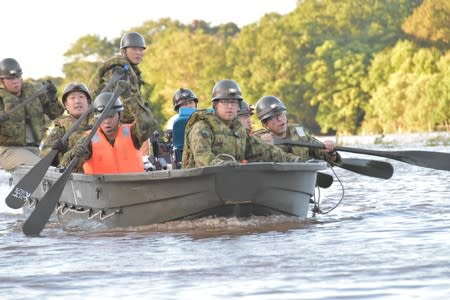 Rescue workers paddle a boat during evacuation operation after a typhoon swept through Kawagoe, Saitama prefecture