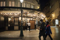 Waiters close a bar terrace in Paris, Saturday, Oct. 17, 2020. French restaurants, cinemas and theaters are trying to figure out how to survive a new curfew aimed at stemming the flow of record new coronavirus infections. The monthlong curfew came into effect Friday at midnight, and France is deploying 12,000 extra police to enforce it. (AP Photo/Lewis Joly)