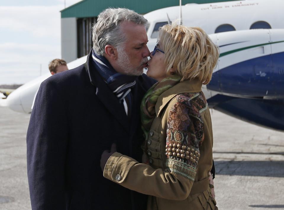 Liberal leader Philippe Couillard kisses his wife Suzanne Pilote as he arrives in Roberval