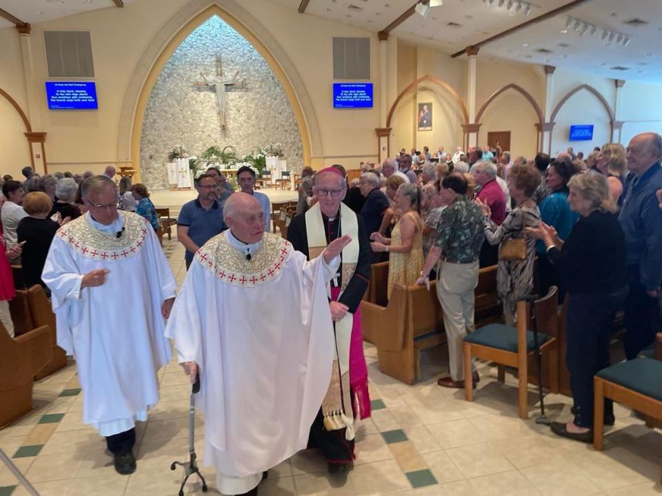Monsignor David Page leads a procession Sunday at Holy Name of Jesus Catholic Church in Indialantic.