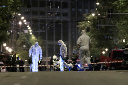 Forensics experts work at the scene after a bomb blast, in central Athens, Greece, April 19, 2017. REUTERS/Alkis Konstantinidis