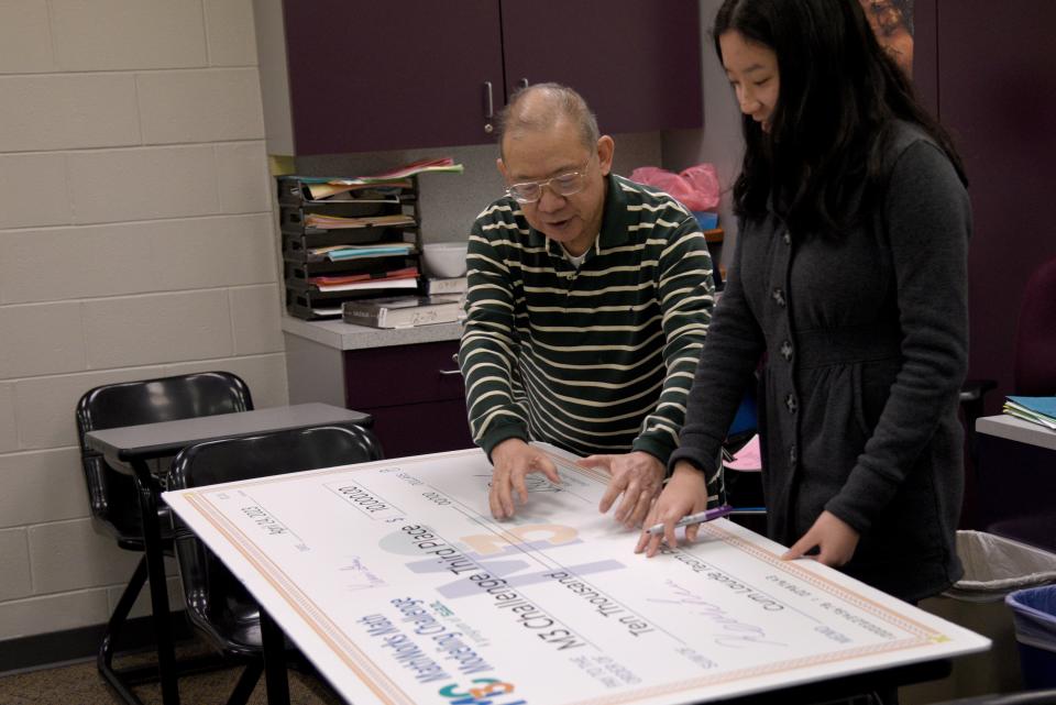 Dr. Raymond Eng shows Amanda Lin where he intends to place the team’s photo on the $10,000 check on Friday, April 28, 2023 at High Technology High School in Middletown, New Jersey. Lin is part of a team that won 3rd place in a math modeling competition. 