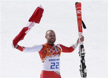 Canada's third-placed Jan Hudec celebrates with a flag during a flower ceremony after the men's alpine skiing Super-G competition during the 2014 Sochi Winter Olympics at the Rosa Khutor Alpine Cente February 16, 2014. REUTERS/Mike Segar