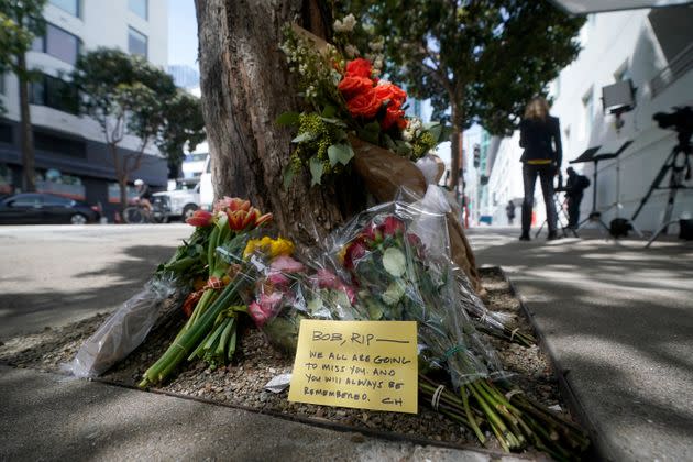 Flowers sit at a tree in front of the building where technology executive Bob Lee was fatally stabbed.