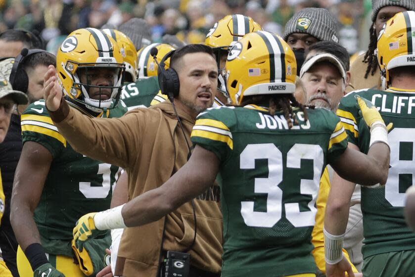 Packers running back Aaron Jones (33) celebrates with head coach Matt LaFleur.