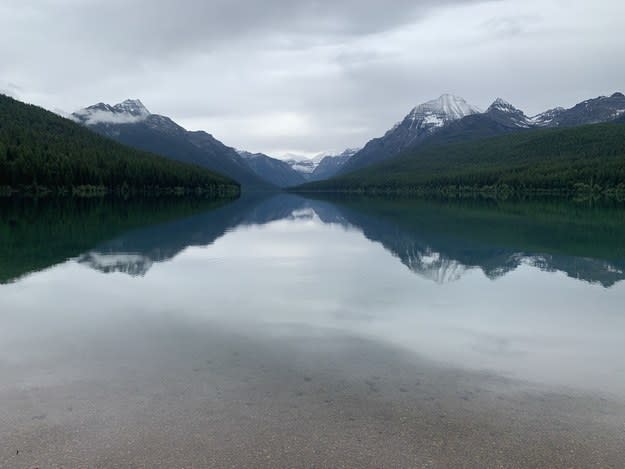 Glacier National Park's mountains are mirrored on the lake surface.