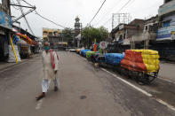 A man wearing a face mask walks on a deserted street in Prayagraj, India, Saturday, July 11, 2020. In just three weeks, India went from the world’s sixth worst-affected country by the coronavirus to the third, according to a tally by Johns Hopkins University. India's fragile health system was bolstered during a stringent monthslong lockdown but could still be overwhelmed by an exponential rise in infections. (AP Photo/Rajesh Kumar Singh)