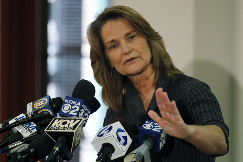 Barbara Baker, CEO and president of the Pittsburgh Zoo and PPG Aquarium, gestures to indicate the slope of a railing that is in the observation area of the African Painted Dog exhibit during a news conference on Monday, Nov. 5, 2012, in Pittsburgh. Zoo officials said a young boy was killed after he fell into the exhibit and the dogs mauled him on Sunday, Nov. 4, 2012. (AP Photo/Keith Srakocic)