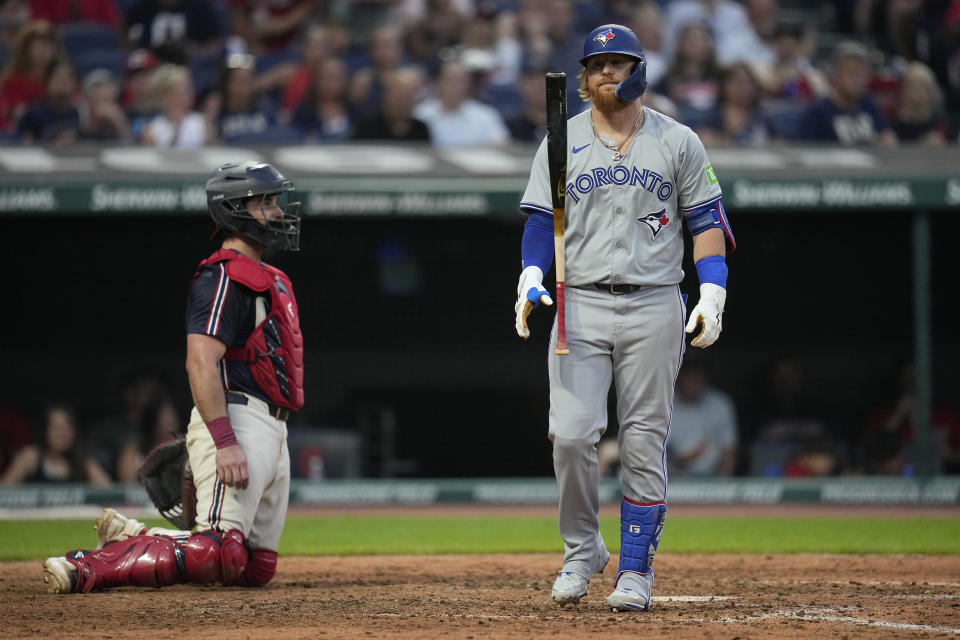 Toronto Blue Jays' Justin Turner, right, flips his bat in front of Cleveland Guardians catcher Austin Hedges, left, after being called out on strikes during the sixth inning of a baseball game Friday, June 21, 2024, in Cleveland. (AP Photo/Sue Ogrocki)