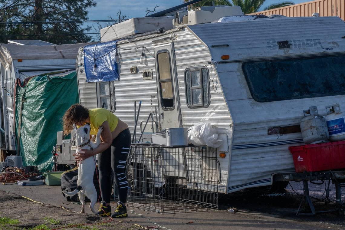 Nicole Stuart seeks comfort in her dog Zenvader outside her trailer in North Sacramento on Dec. 21. The group was notified they might be swept and she was concerned about her dogs if she couldn’t tow her trailer.