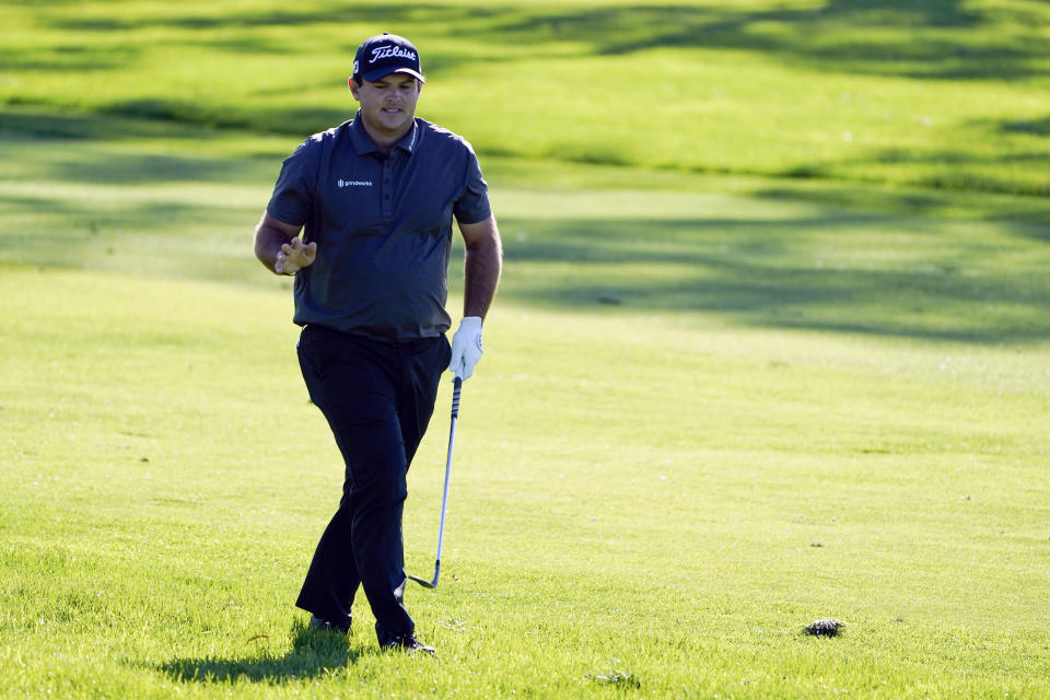 Patrick Reed reacts to fans watching from a nearby hotel after his second shot on the 18th hole of the South Course during the third round of the Farmers Insurance Open golf tournament at Torrey Pines, Saturday, Jan. 30, 2021, in San Diego. (AP Photo/Gregory Bull)