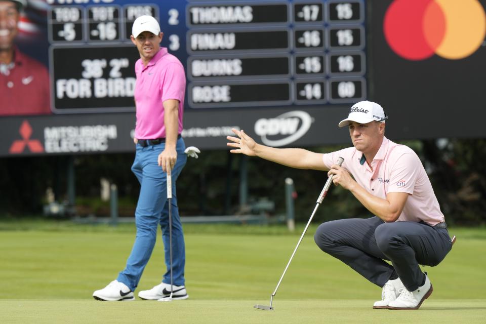 Justin Thomas, right, gestures for fans to stop moving as he and Rory McIlroy line up their putts on the 16th green during the final round of the Canadian Open golf tournament in Toronto, Sunday, June 12, 2022. (Frank Gunn/The Canadian Press via AP)