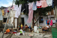 <p>Residents of the Mangueira favela sit outside their homes in Rio de Janeiro, May 2, 2017. (Photo: Mario Tama/Getty Images) </p>