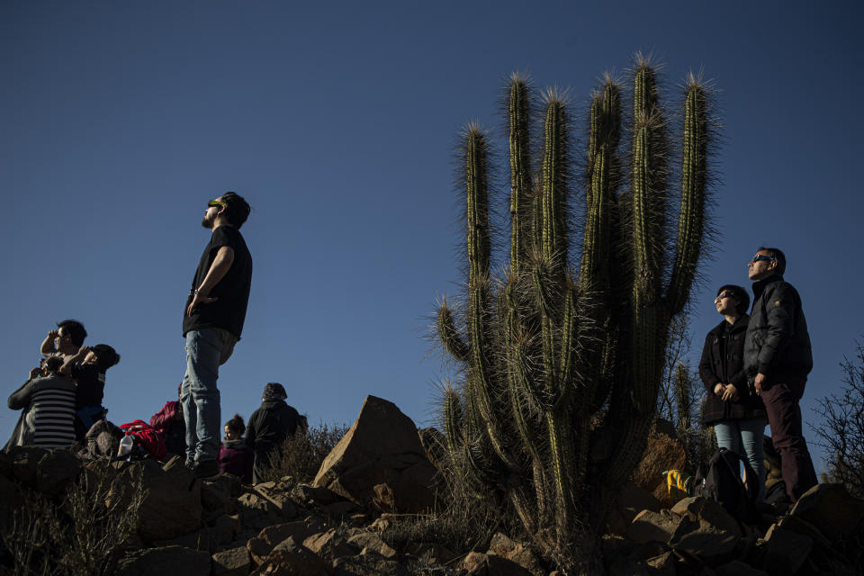 People watch a total solar eclipse in La Higuera, Chile, Tuesday, July 2, 2019. Tens of thousands of tourists and locals gaped skyward Tuesday as a rare total eclipse of the sun began to darken the heavens over northern Chile. (AP Photo/Esteban Felix)