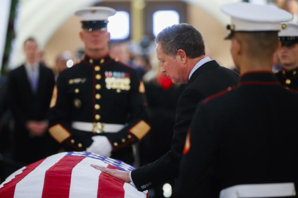 Ohio Gov. John Kasich touches the casket of John Glenn as he lies in honor, Friday, Dec. 16, 2016, in Columbus, Ohio. Glenn's home state and the nation began saying goodbye to the famed astronaut who died last week at the age of 95. (AP Photo/John Minchillo)
