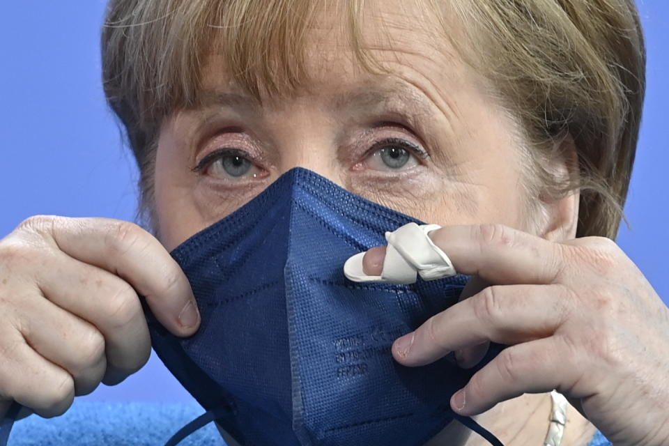 German Chancellor Angela Merkel puts her face mask on after a press conference after the informal EU summit and the EU-China summit in Berlin, Germany, Saturday, May 8, 2021. Merkel reiterated her stance that the shortage of vaccines worldwide would not be solved by a waiver of patents, as suggested by U.S. President Biden. (John MacDougall/Pool Photo via AP)