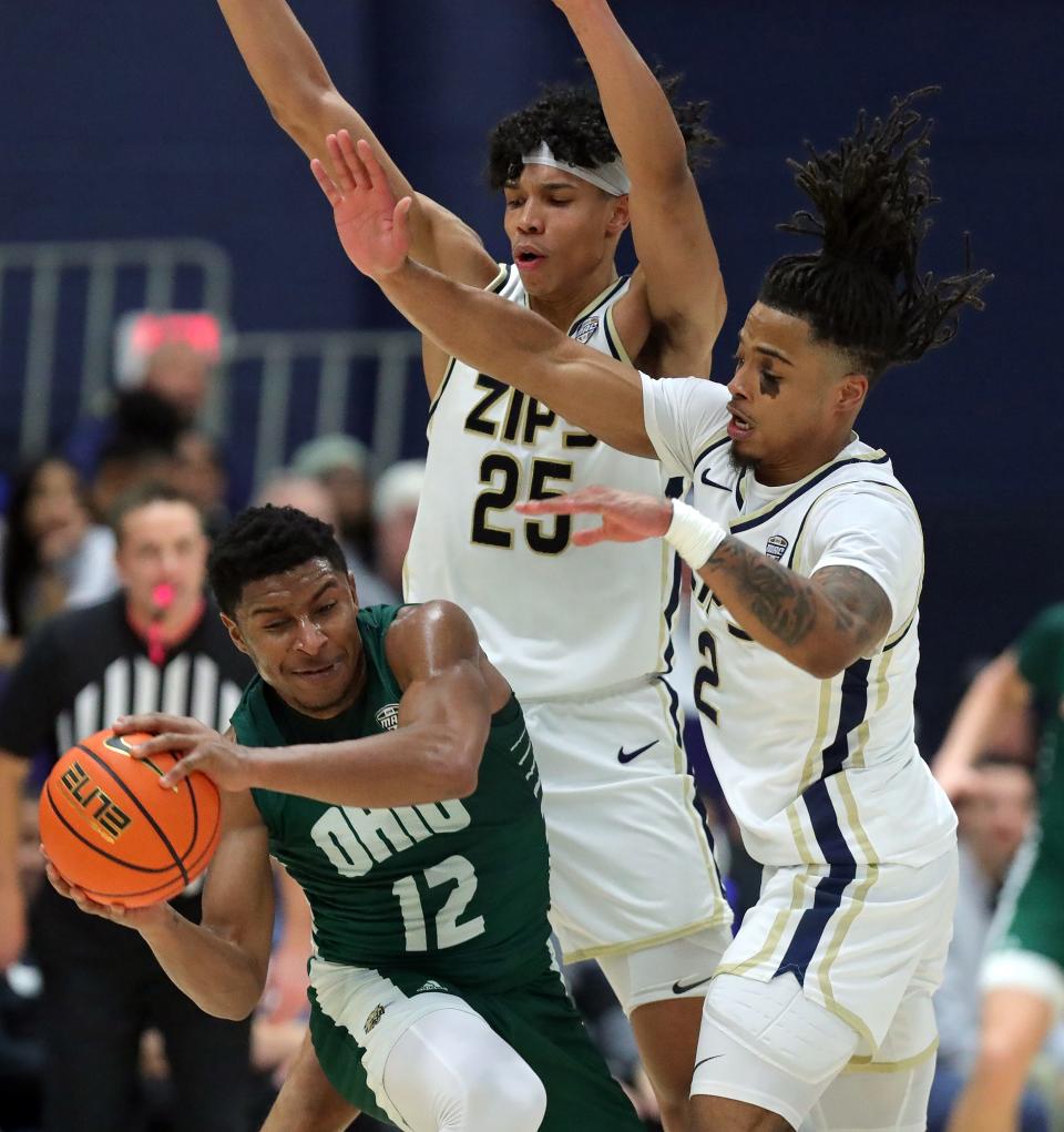 Akron Zips forward Enrique Freeman (25) and guard Greg Tribble (2) apply pressure to Ohio's Jaylin Hunter during the first half, Tuesday, Jan. 23, 2024.