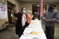 People check in to vote at Lynn City Hall, Friday, Oct. 30, 2020, in Lynn, Mass. Friday is the final day for early voting before the general election in Massachusetts. (AP Photo/Michael Dwyer)