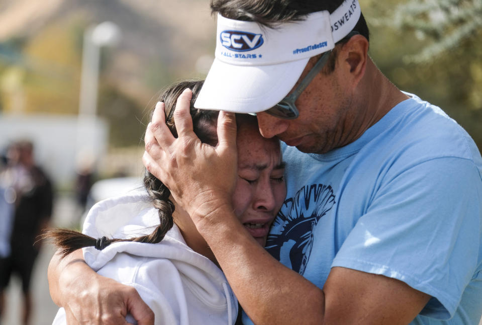 Ella Cabigting is embraced by her father Emerson as they reunite following a shooting at Saugus High School that injured several people, Thursday, Nov. 14, 2019, in Santa Clarita, Calif. (AP Photo/Ringo H.W. Chiu)