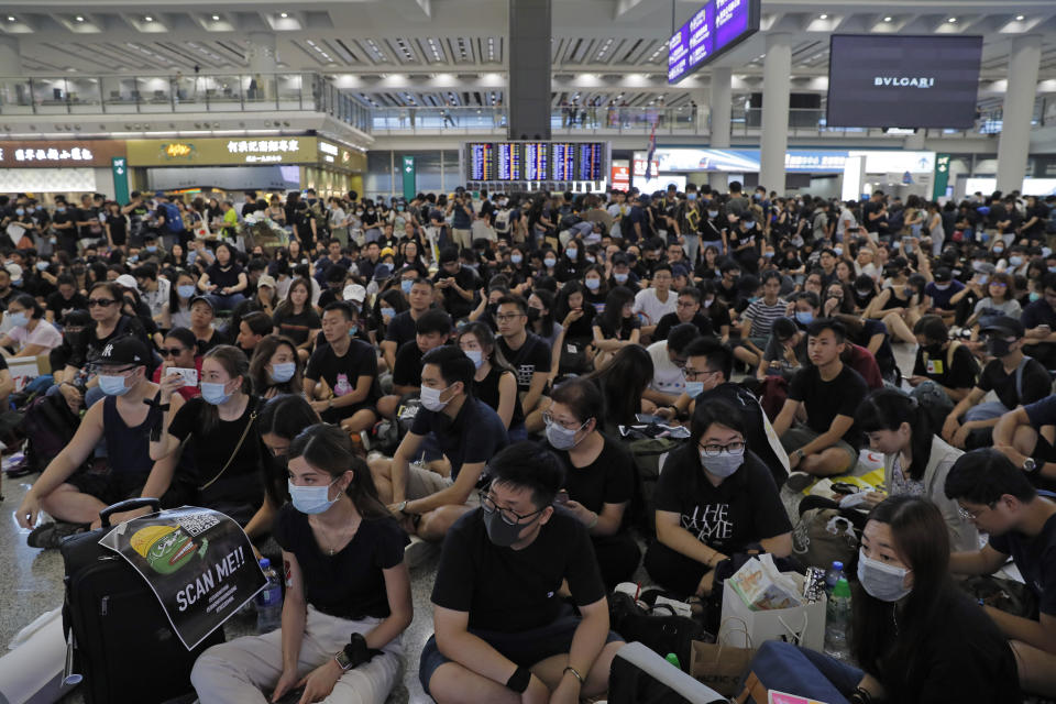 Thousands take part in a second day of sit-in protest at the airport in Hong Kong on Saturday, Aug. 10, 2019. Hong Kong is in its ninth week of demonstrations that began in response to a proposed extradition law but have expanded to include other grievances and demands for more democratic freedoms. (AP Photo/Kin Cheung)