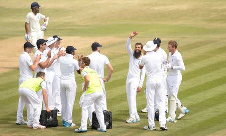 England's Moeen Ali (4th R) acknowledges the crowd by holding the ball after taking his fifth wicket during the third cricket test match against India at the Rose Bowl cricket ground, Southampton, England July 31, 2014. REUTERS/Philip Brown