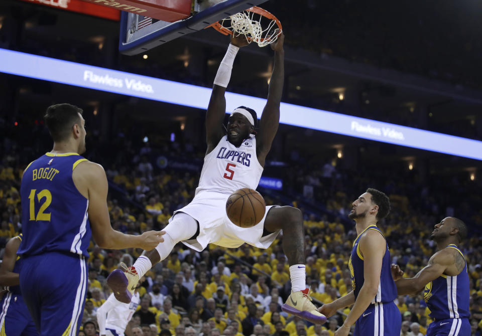 Los Angeles Clippers' Montrezl Harrell (5) scores as Golden State Warriors' Andrew Bogut (12), Klay Thompson, second from right, and Andre Iguodala watch during the second half in Game 5 of a first-round NBA basketball playoff series, Wednesday, April 24, 2019, in Oakland, Calif. (AP Photo/Ben Margot)