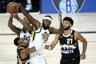 Utah Jazz's Jordan Clarkson, back, competes for a rebound with teammate Royce O'Neale, right, and Denver Nuggets' Monte Morris, left, during overtime in an NBA basketball first round playoff game, Monday, Aug. 17, 2020, in Lake Buena Vista, Fla. Nuggets' Jamal Murray (27) looks on. The Nuggets won 135-125 in overtime. (AP Photo/Ashley Landis, Pool)