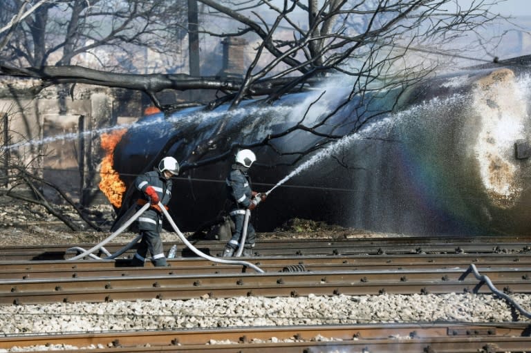 Firefighters spray water on a train that derailed in the northeastern Bulgarian village of Hitrino on December 10, 2016