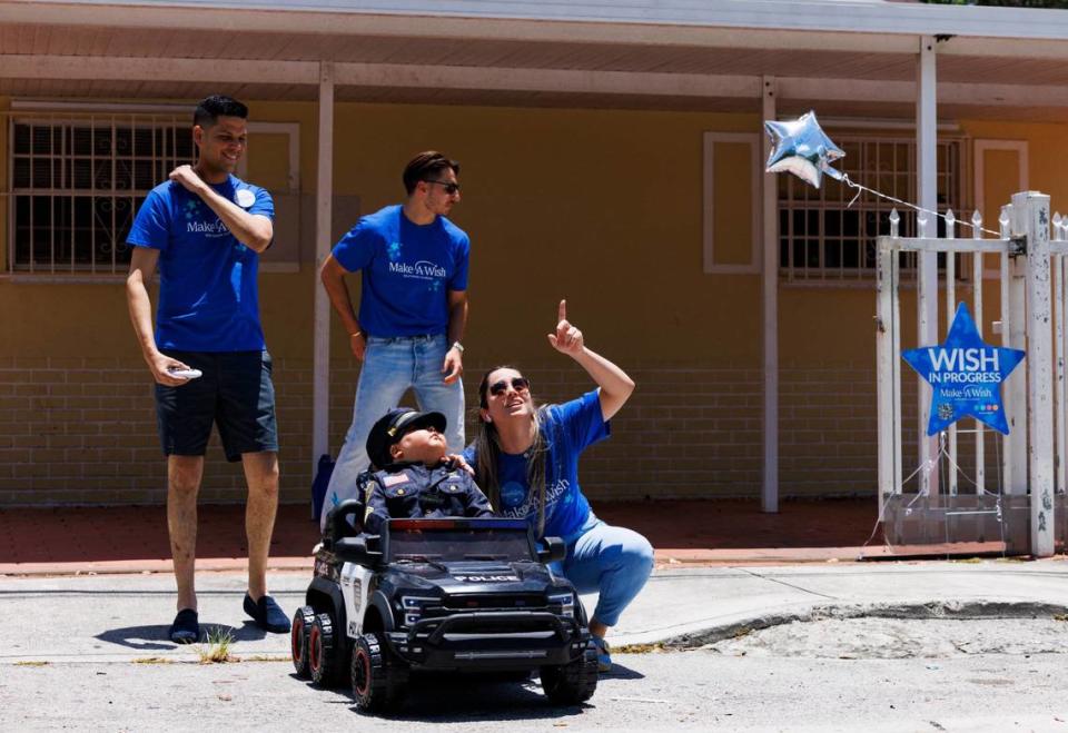 Wendy Bernal, right, mother of Franco, 6, who is battling childhood leukemia, points up to the sky where a fly over is taking place during his Wish Reveal on Thursday, July 18, 2024, with a parade by Make-A-Wish and City of Miami Police in Miami.