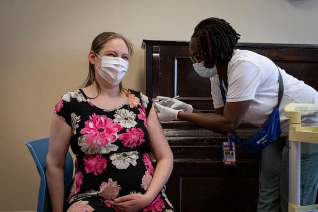 Emma Willemsma, who is pregnant, gets her first dose of the Moderna vaccine at a pop-up clinic run by Humber River Hospital at the Luso Canadian Charitable Society in Toronto on Friday.