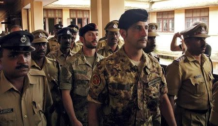 Salvatore Girone (C) and Latorre Massimiliano (3rd R), members of the navy security team of Napoli registered Italian merchant vessel Enrica Lexie, are escorted as they leave a courtroom at Kollam in Kerala March 5, 2012. REUTERS/Sivaram V/Files